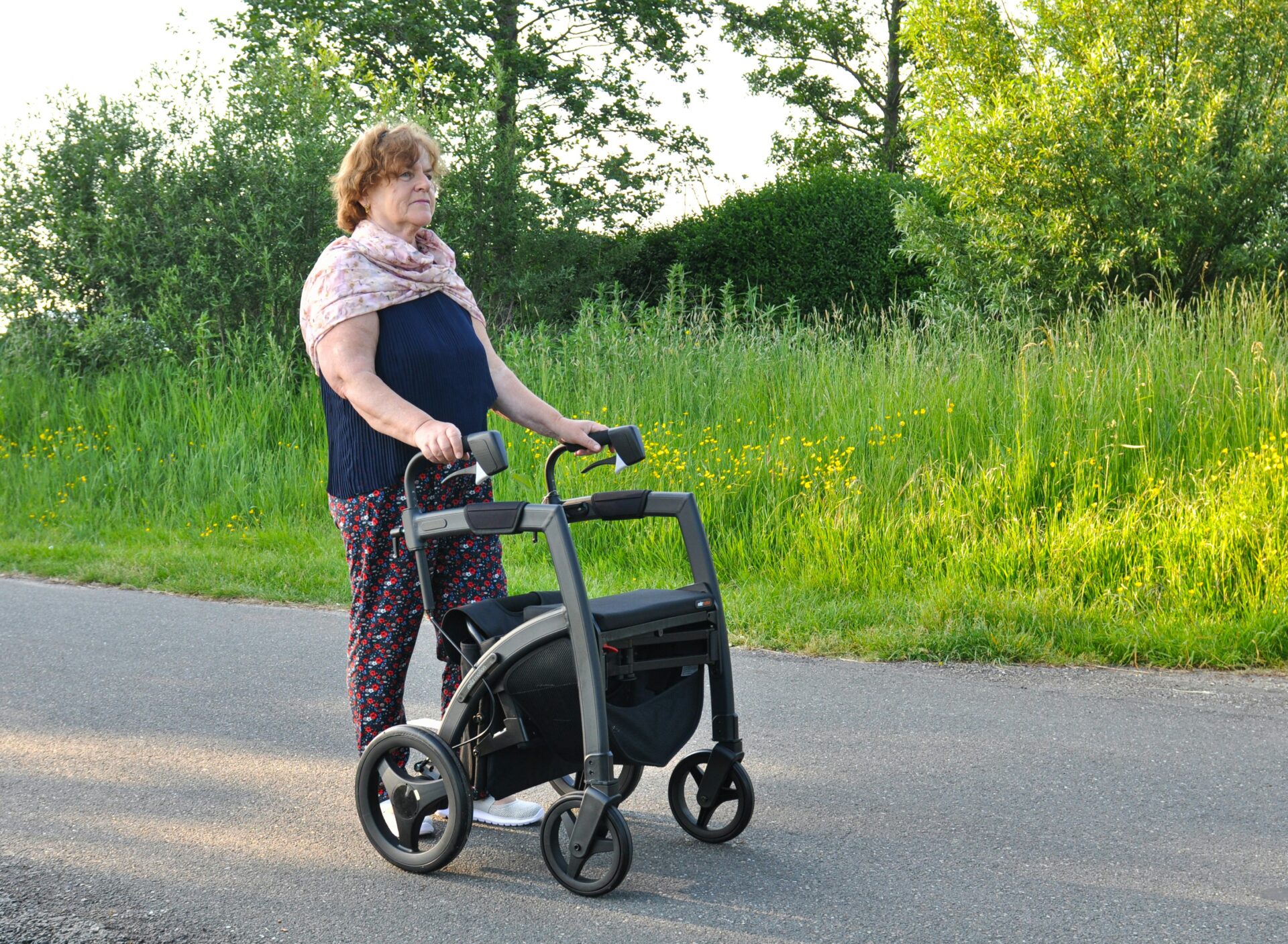 a woman pushing a walker down the street